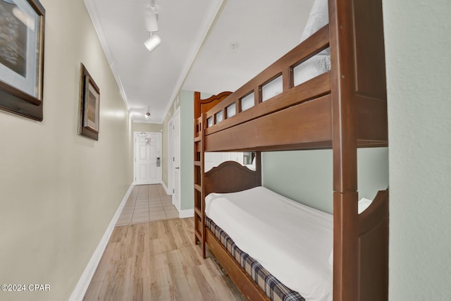 bedroom with light wood-type flooring, rail lighting, and crown molding