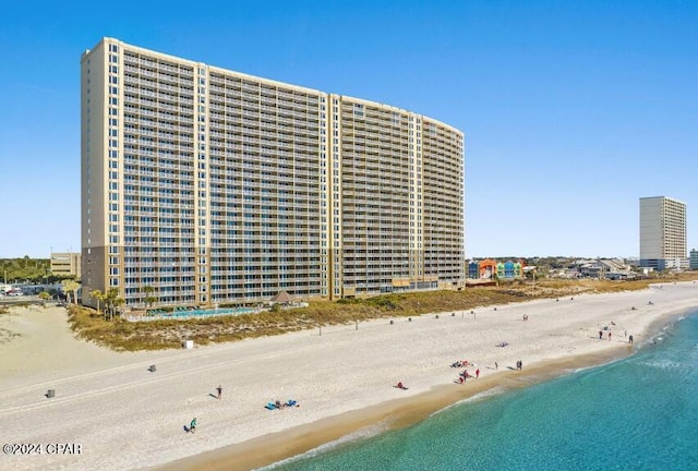 view of building exterior featuring a beach view and a water view