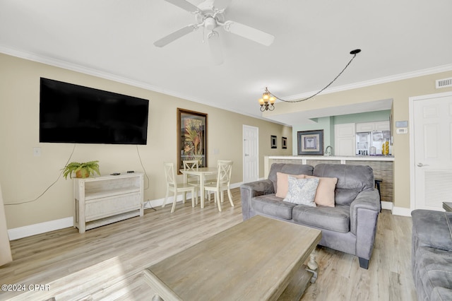 living room featuring ornamental molding, light wood-type flooring, and ceiling fan