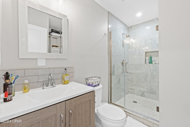 bathroom with vanity, toilet, an enclosed shower, and decorative backsplash