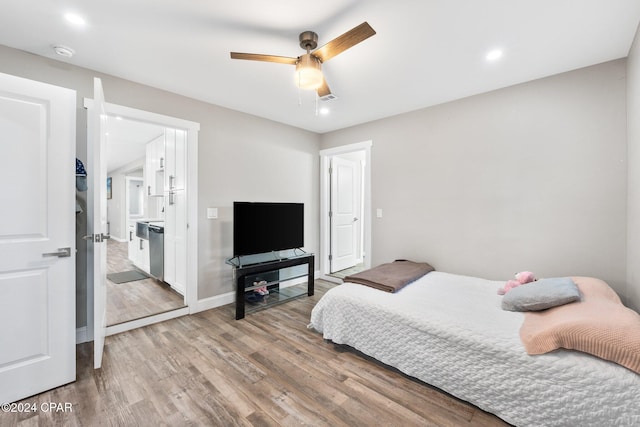 bedroom with light hardwood / wood-style flooring, ceiling fan, and ensuite bathroom