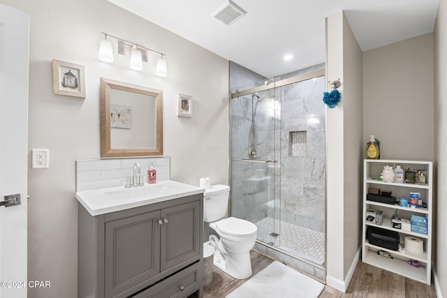 bathroom with hardwood / wood-style flooring, vanity, toilet, and an enclosed shower