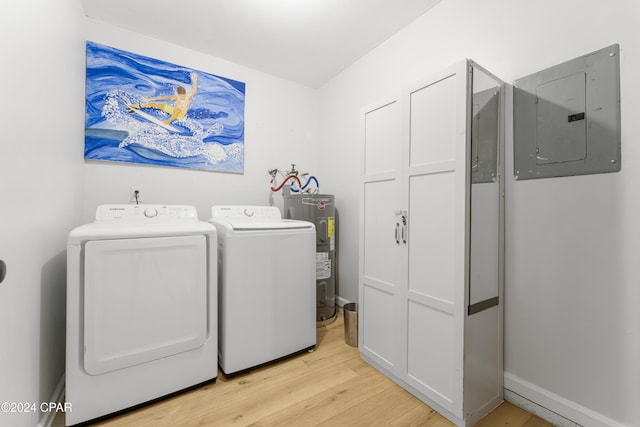 clothes washing area with light hardwood / wood-style floors, electric water heater, washer and dryer, and electric panel