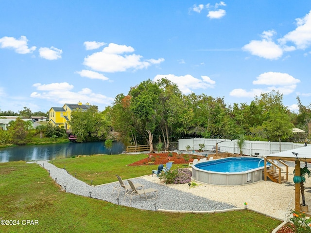 view of pool featuring a lawn and a water view