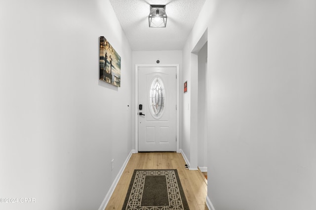 doorway featuring light hardwood / wood-style floors and a textured ceiling