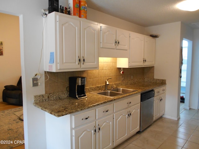 kitchen featuring tasteful backsplash, stainless steel dishwasher, sink, and white cabinets