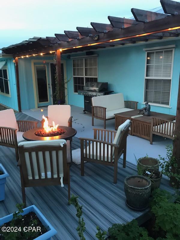 wooden deck featuring a grill and an outdoor living space with a fire pit