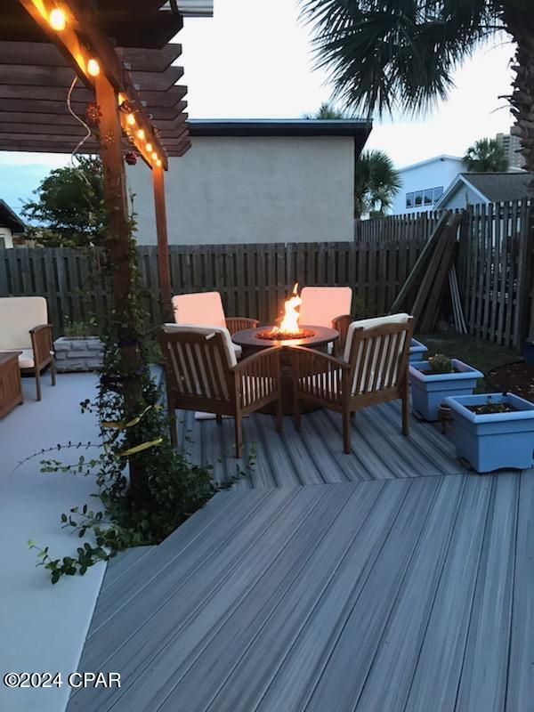 wooden terrace with a pergola and a fire pit