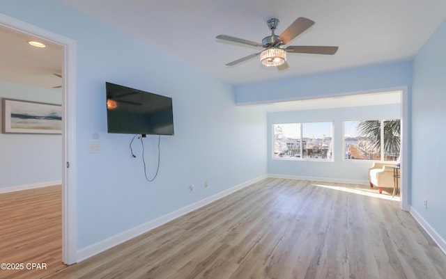 unfurnished living room featuring a ceiling fan, wood finished floors, and baseboards