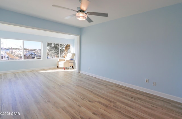 spare room with wood finished floors, baseboards, and ceiling fan