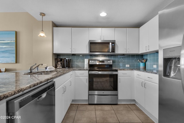 kitchen with pendant lighting, sink, white cabinets, and stainless steel appliances