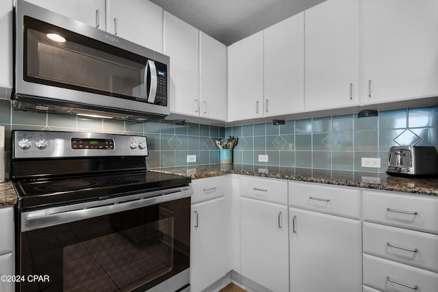 kitchen with decorative backsplash, white cabinetry, and stainless steel appliances