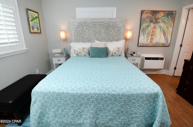 bedroom featuring wood-type flooring and a wall mounted air conditioner