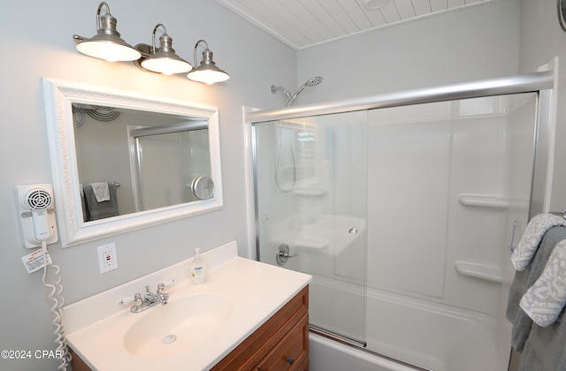 bathroom with vanity and shower / bath combination with glass door