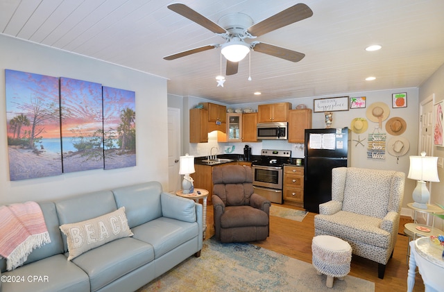 living room with light hardwood / wood-style flooring, sink, and ceiling fan