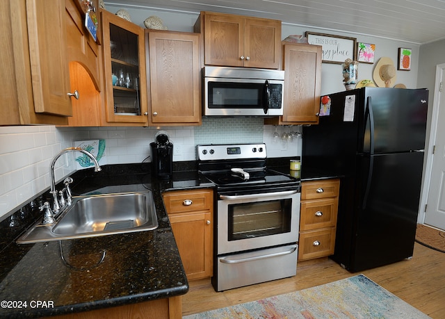 kitchen with sink, appliances with stainless steel finishes, ornamental molding, light hardwood / wood-style flooring, and decorative backsplash