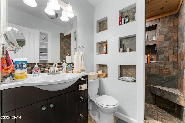 bathroom featuring decorative backsplash, vanity, toilet, and walk in shower