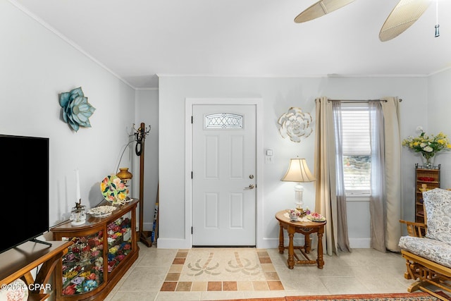 tiled foyer featuring ceiling fan and ornamental molding