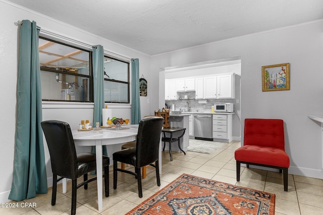 tiled dining space featuring crown molding, sink, and a textured ceiling