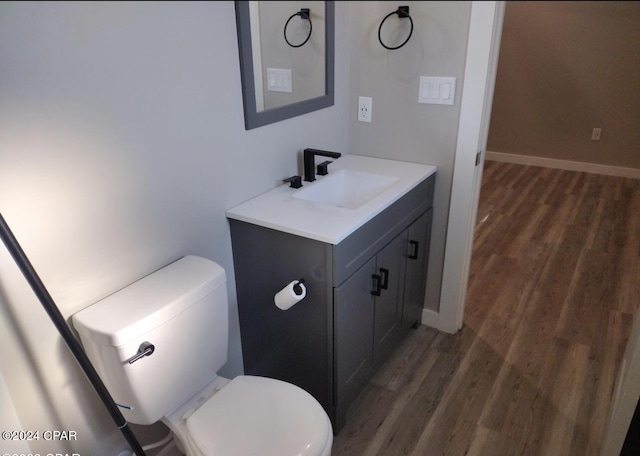 bathroom featuring wood-type flooring, vanity, and toilet