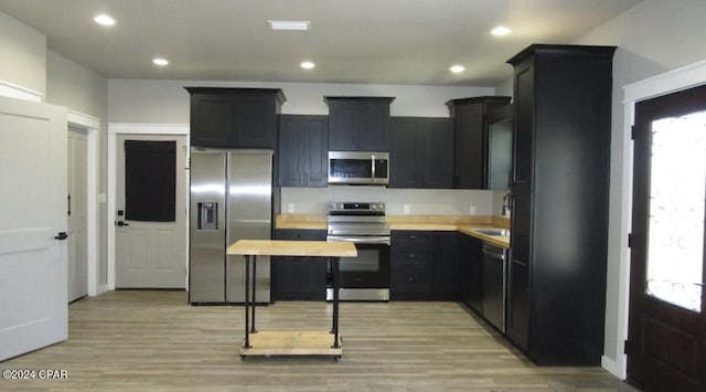 kitchen with butcher block countertops, light hardwood / wood-style flooring, and appliances with stainless steel finishes