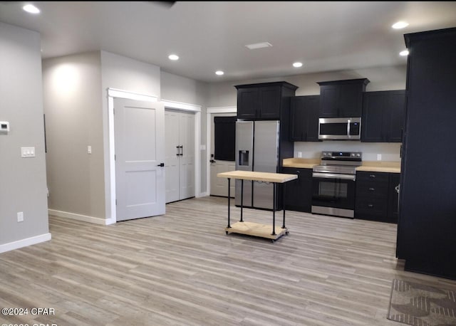 kitchen featuring stainless steel appliances and light hardwood / wood-style flooring