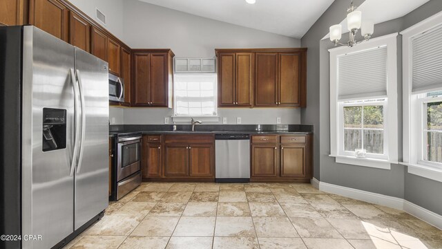 kitchen featuring sink, a chandelier, decorative light fixtures, vaulted ceiling, and appliances with stainless steel finishes