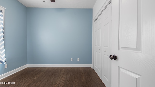 unfurnished bedroom with a closet, dark hardwood / wood-style flooring, and ceiling fan