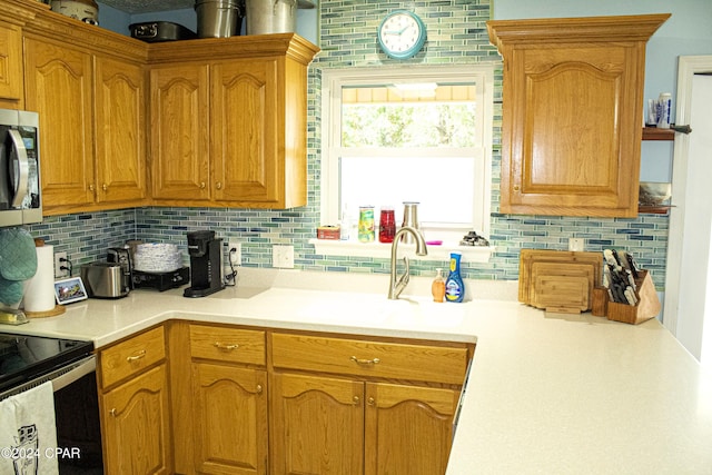 kitchen with decorative backsplash, electric stove, and sink