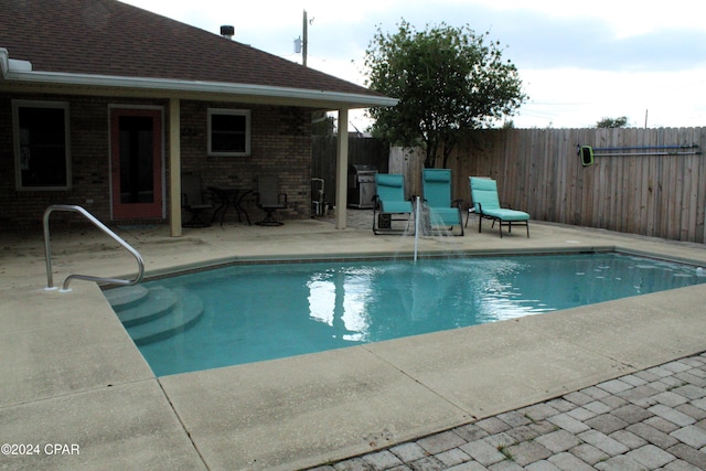 view of pool with a patio and a grill