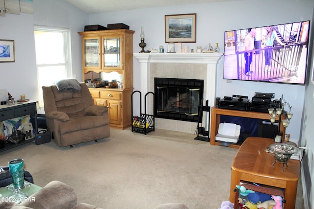 living room featuring light carpet, a tile fireplace, and vaulted ceiling