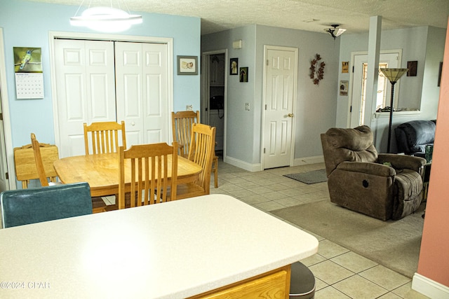 tiled dining area with a textured ceiling