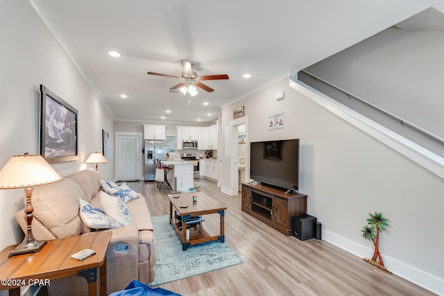 living room featuring ceiling fan, ornamental molding, and light wood-type flooring