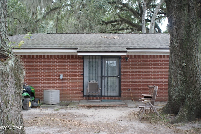 rear view of property with central AC