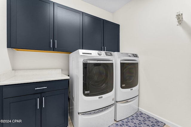 laundry area featuring washer and dryer and cabinets