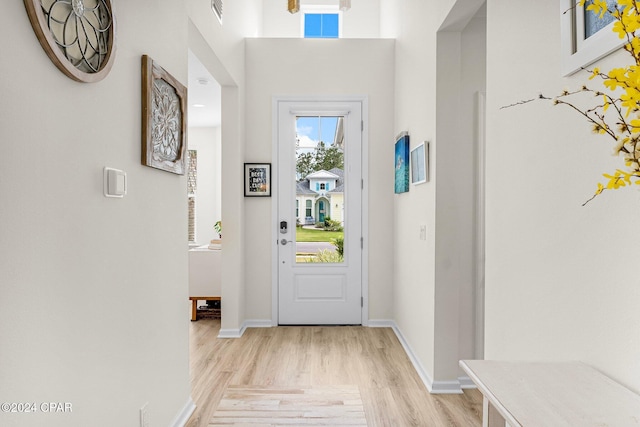 doorway featuring a high ceiling and light hardwood / wood-style flooring