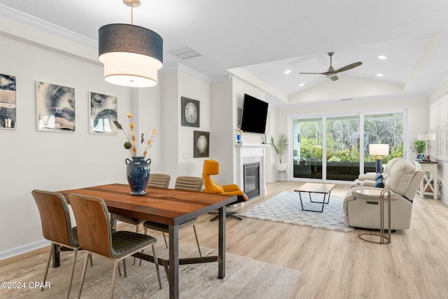 dining area with light hardwood / wood-style floors, ceiling fan, vaulted ceiling, and crown molding