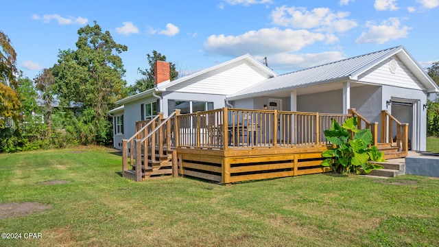 rear view of property with a lawn and a wooden deck