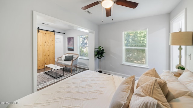 bedroom featuring a barn door and ceiling fan