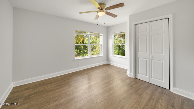 unfurnished bedroom featuring dark hardwood / wood-style flooring, a closet, and ceiling fan