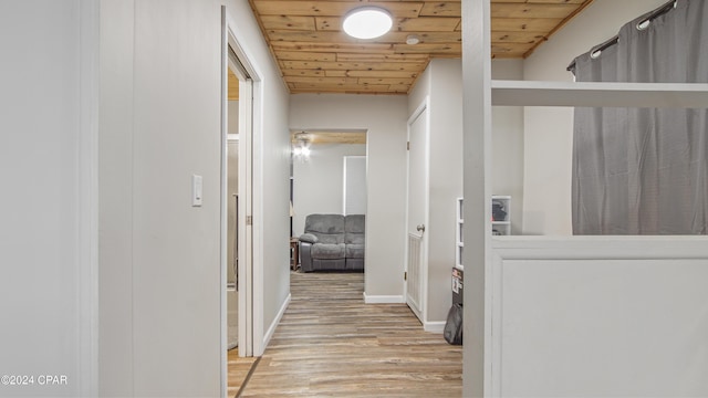 hall featuring light hardwood / wood-style floors and wood ceiling