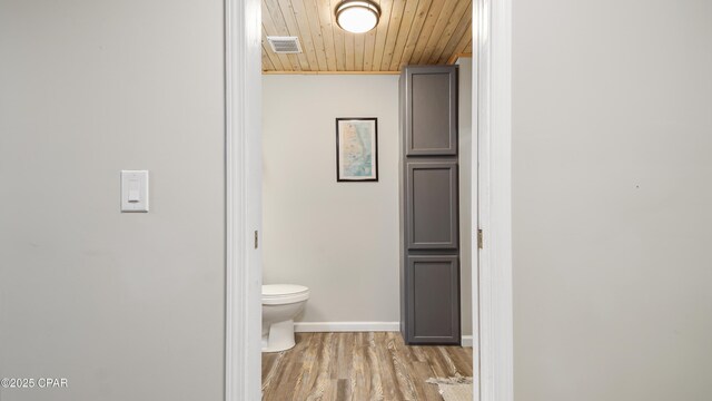 hall featuring dark wood-type flooring and wooden ceiling