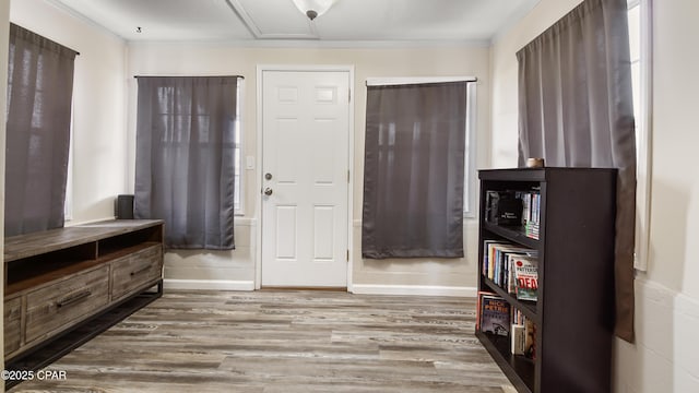 foyer entrance with hardwood / wood-style floors and crown molding