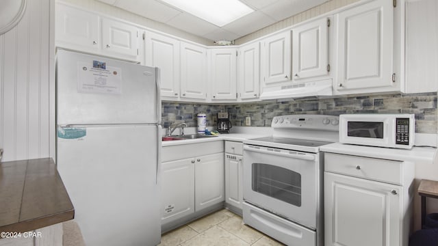 kitchen with a paneled ceiling, custom exhaust hood, white appliances, white cabinets, and sink