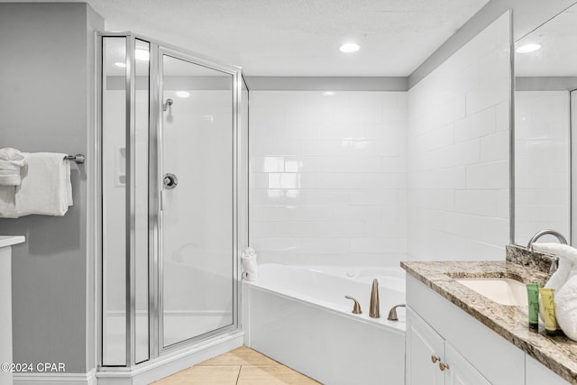 bathroom with vanity, independent shower and bath, and a textured ceiling