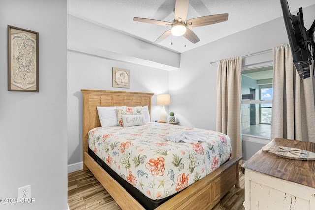 bedroom featuring hardwood / wood-style floors, a textured ceiling, and ceiling fan