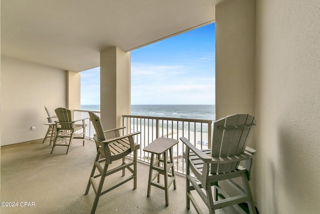 balcony with a beach view and a water view