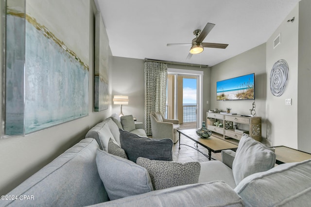 living room with ceiling fan and light hardwood / wood-style flooring