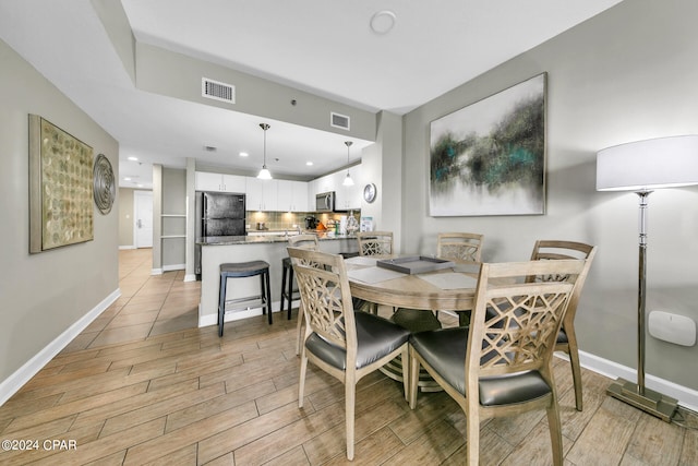 dining space with light hardwood / wood-style floors