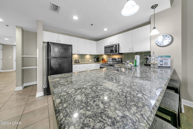 kitchen with white cabinetry, hanging light fixtures, stainless steel appliances, a kitchen breakfast bar, and kitchen peninsula